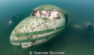 Diver examines a Plane wreck. Cockpit lit with off camera... by Spencer Burrows 